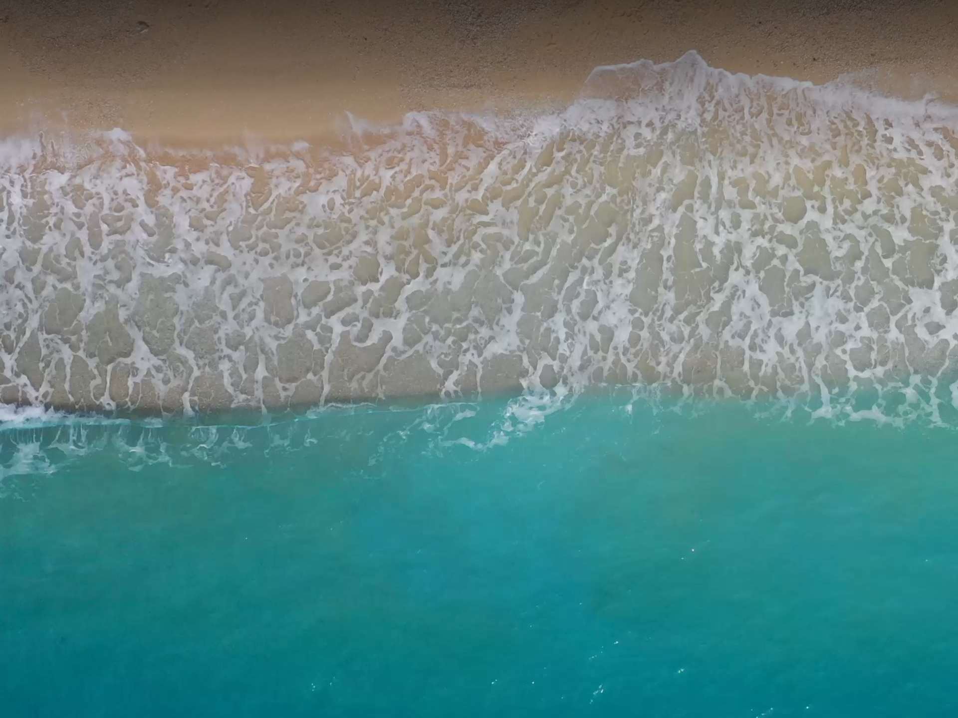 Aerial view of beach sand and water