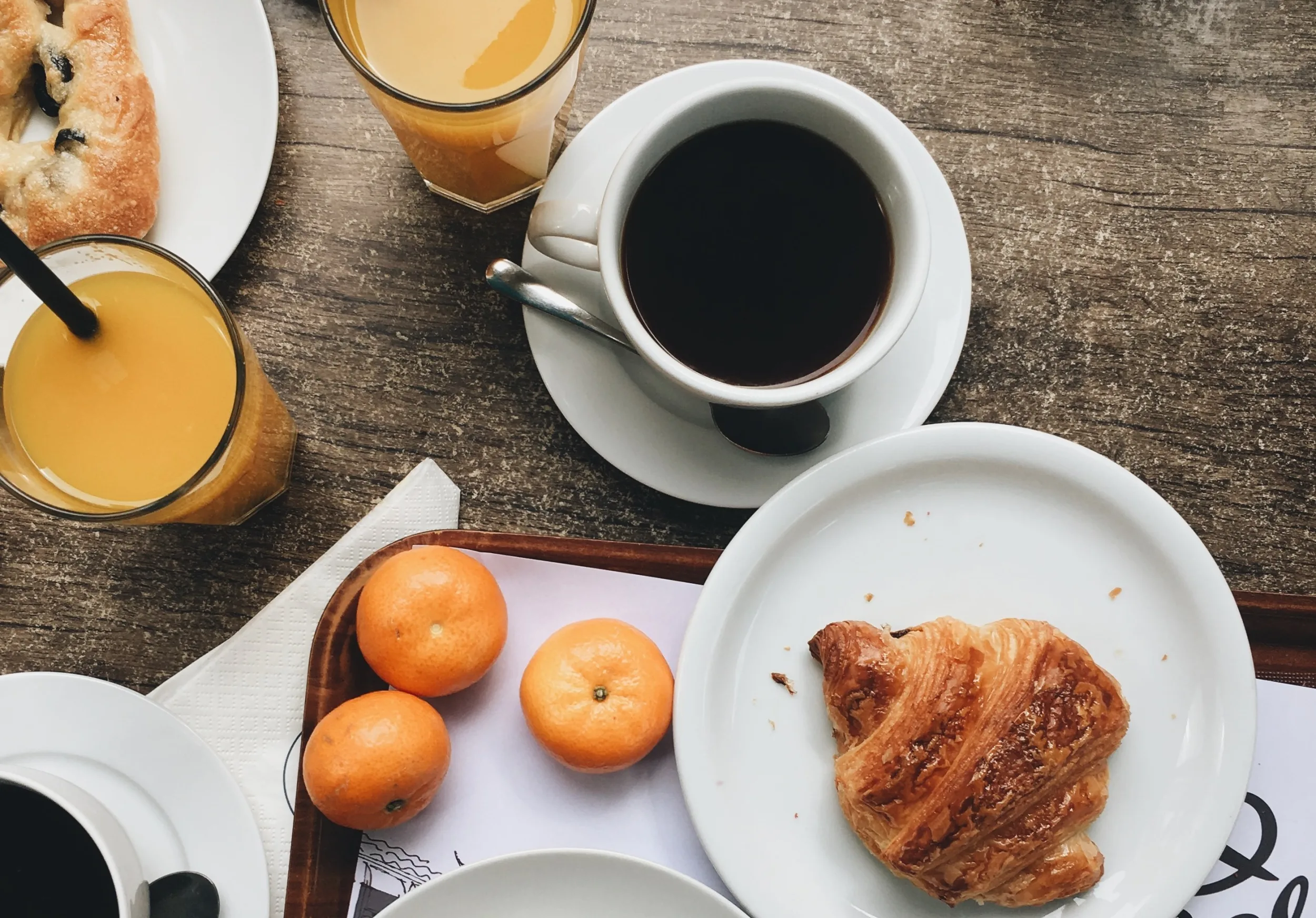 Breakfast consisting of fruit, baked goods, coffee and juice on a table
