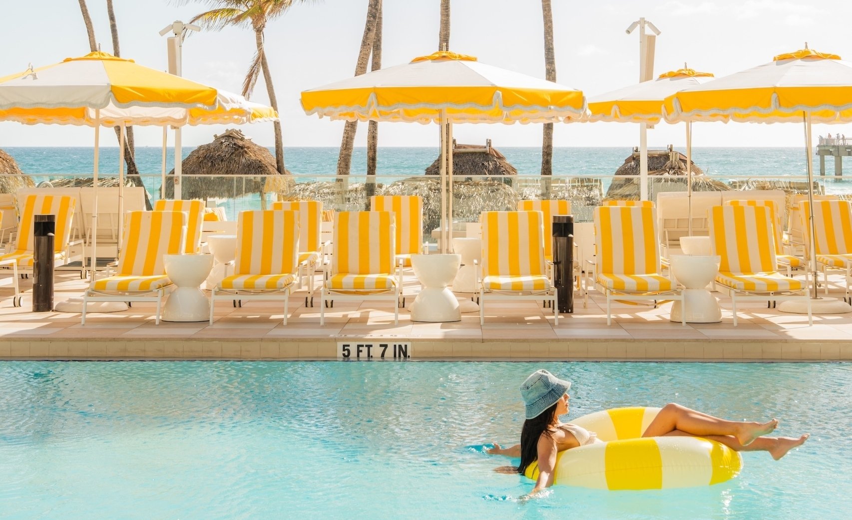 Woman with a tube in outdoor swimming pool with the Sunny cabanas
