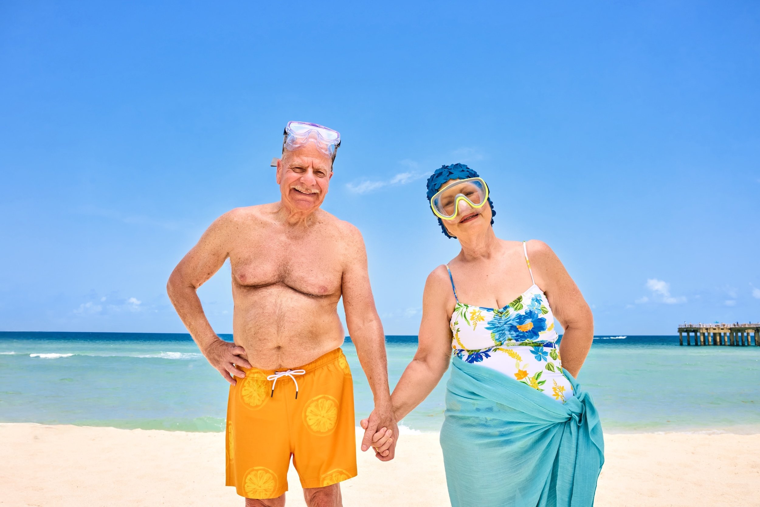 Old couple holding hands on Sunny Isles Beach