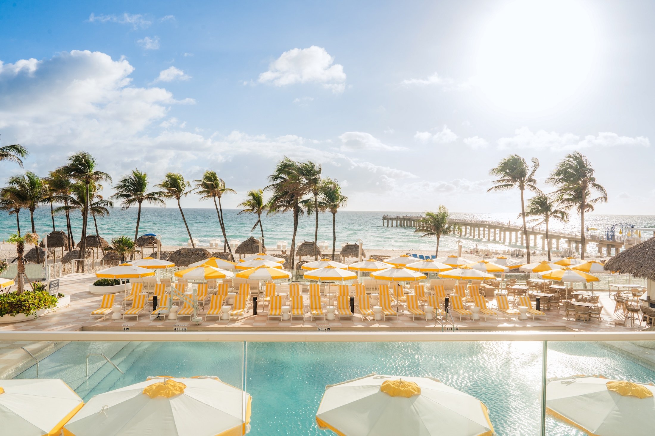Outdoor swimming pool with yellow parasols and Miami beach